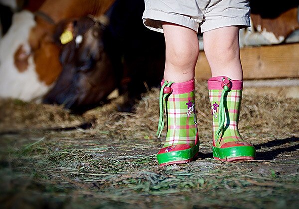 Enfant en bottes dans un étable