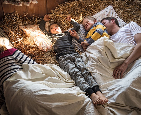 Eine Familie schläft im Stroh