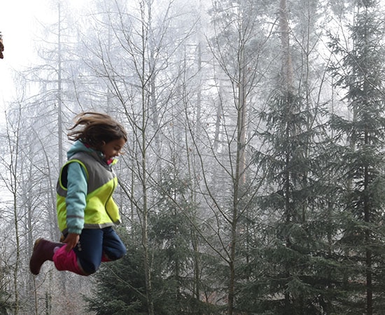 Schule und Wald: springendes Kind