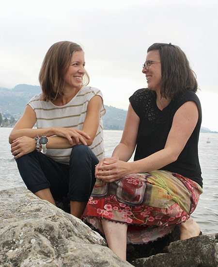Two women chatting siting on the beach