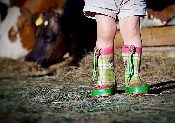 Enfant en bottes dans un étable
