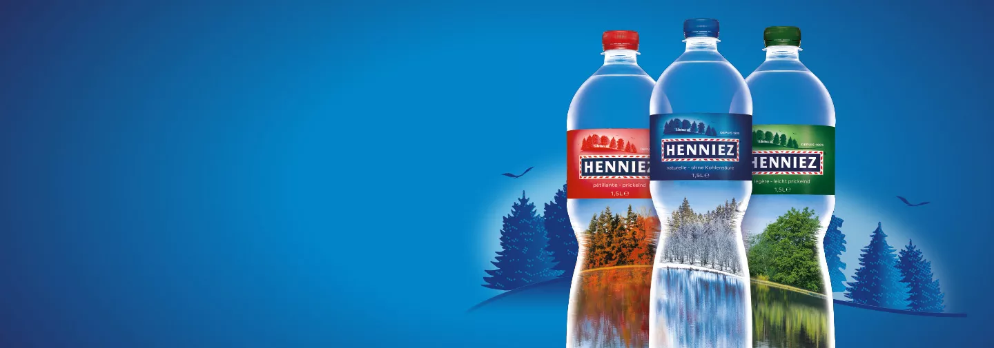Forêt à travers les bouteilles d'eau HENNIEZ